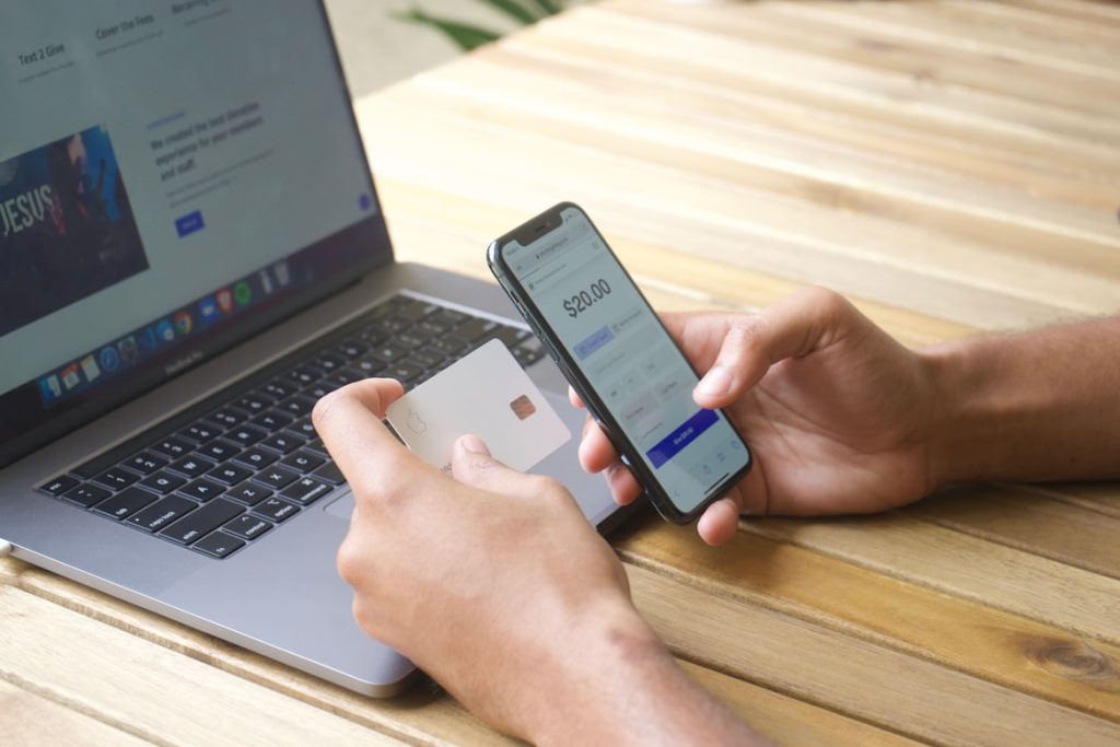 Person holding a credit card and smartphone to file a chargeback on a mobile banking app.