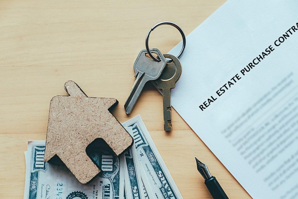 Real estate purchase contract with house keys and cash, used in VA loans home buying process