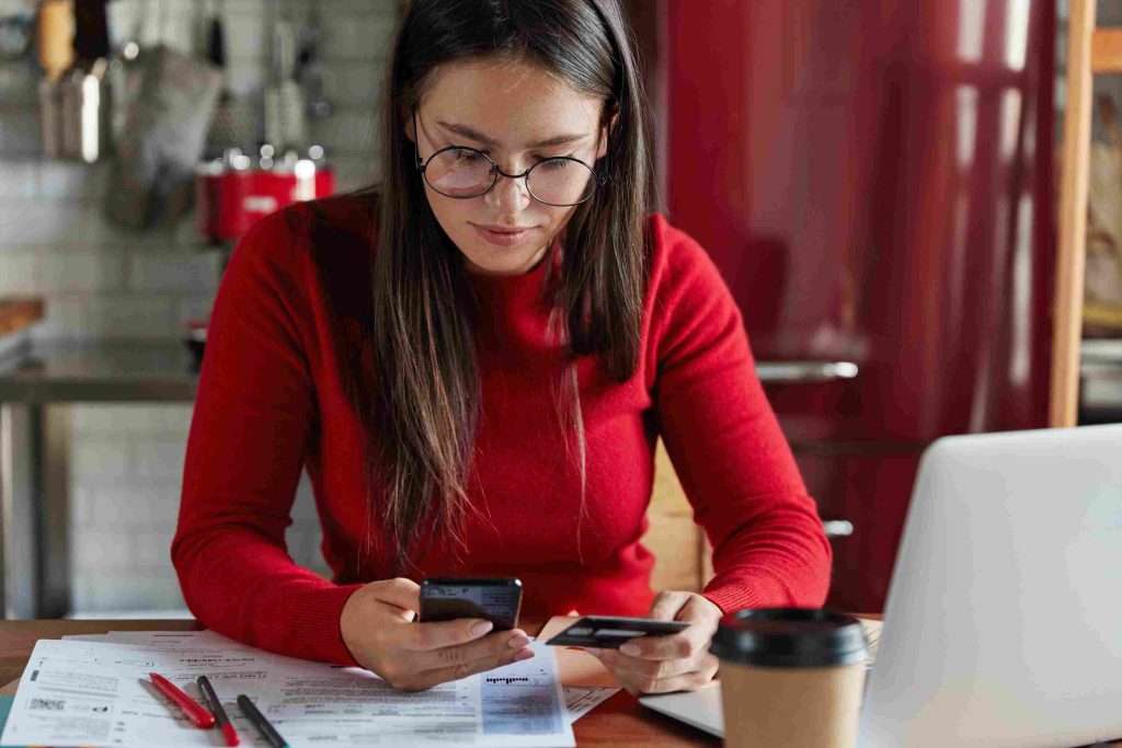 Woman reviewing finances, understanding hard vs soft credit inquiry impact on her credit score