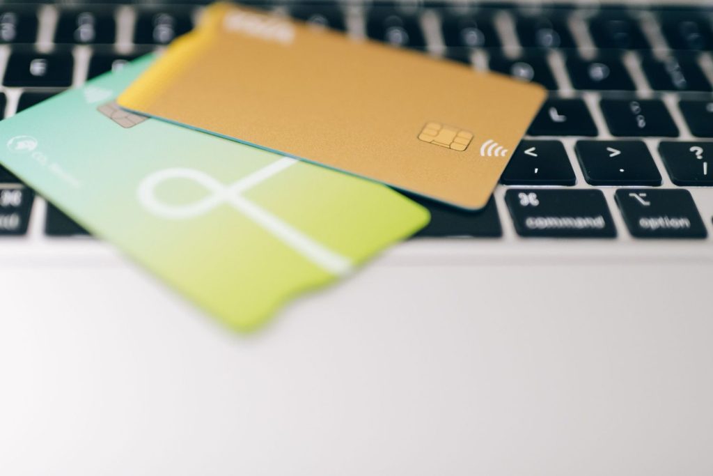 Two credit cards resting on a laptop keyboard for online spending.