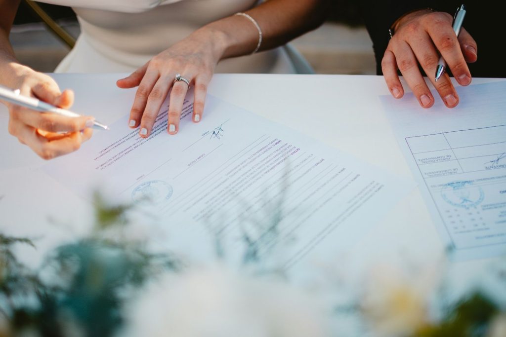 Couple signing a will and trust document during an estate planning meeting.