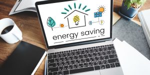 A laptop displaying energy saving tips and eco-friendly icons on how to reduce electricity bill at home.