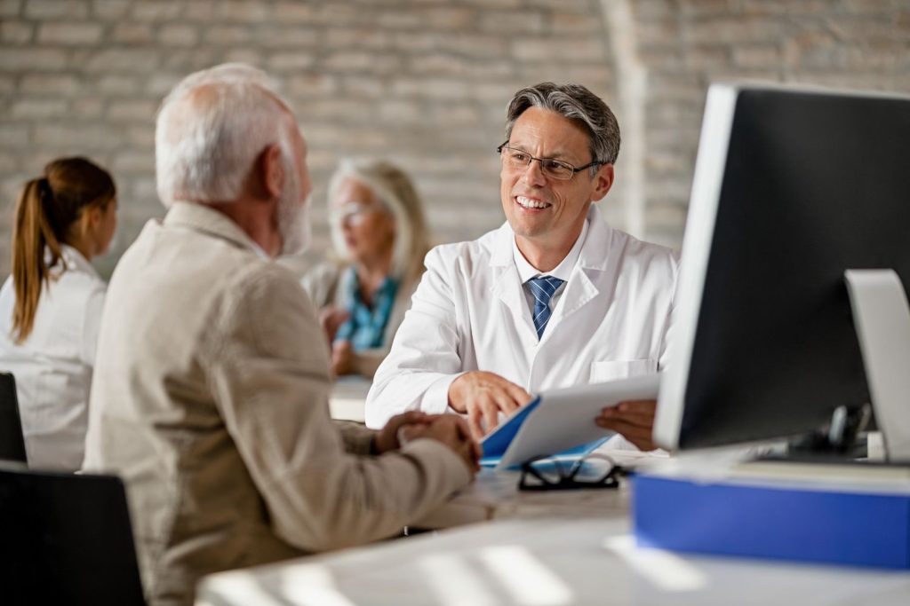 Patient reviews coverage options with a doctor during a Medicaid and Medicare consultation at a clinic.