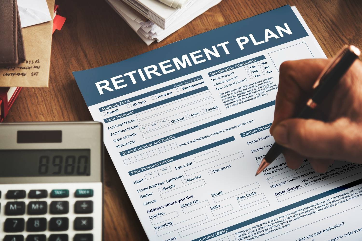 Retirement plan form with calculator and paperwork showing 403b and 401k retirement planning decisions.