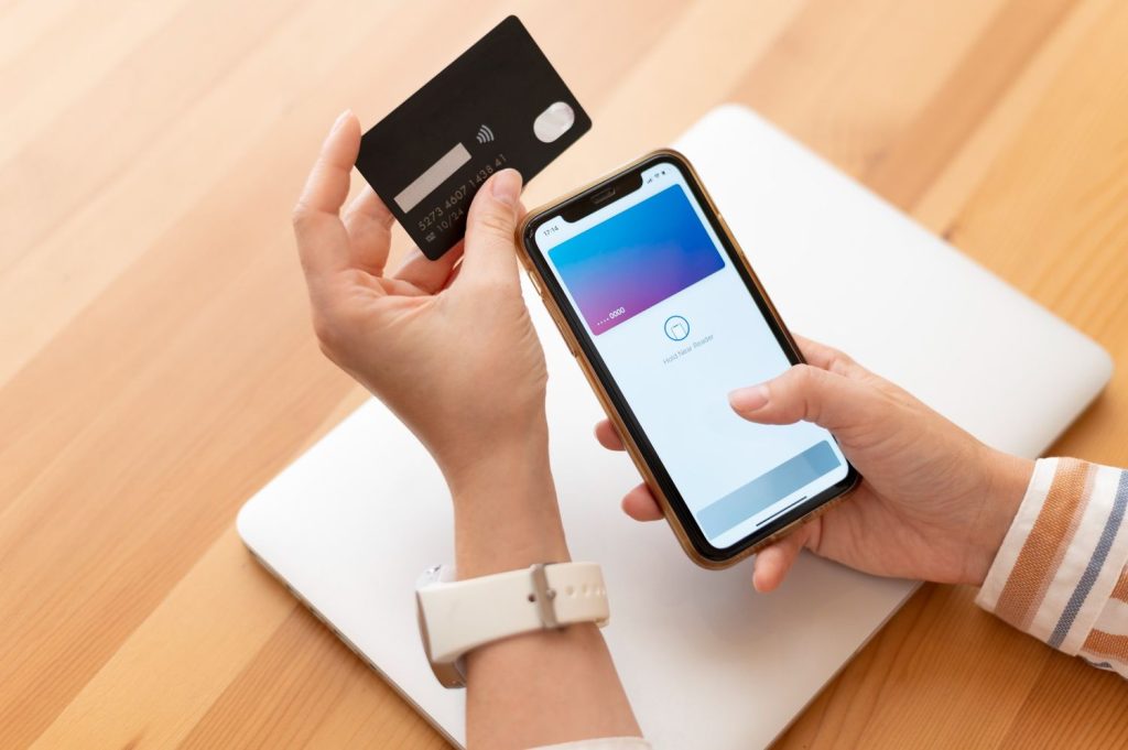Person confirming an online payment with a credit card for a checking account transaction on a phone.