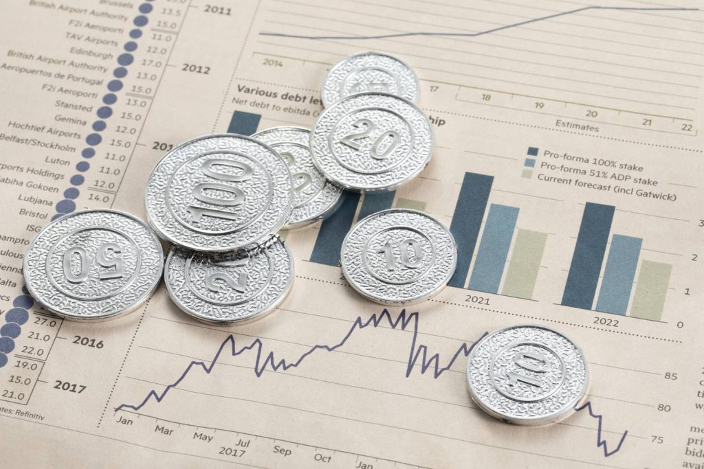 Silver coins on financial reports highlight tracking performance and returns with an index fund.
