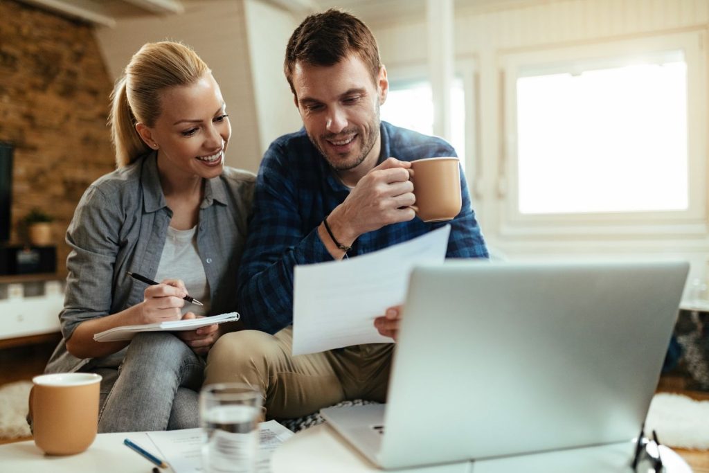 Couple reviewing household finances on a laptop while exploring payday loan alternatives for managing expenses.