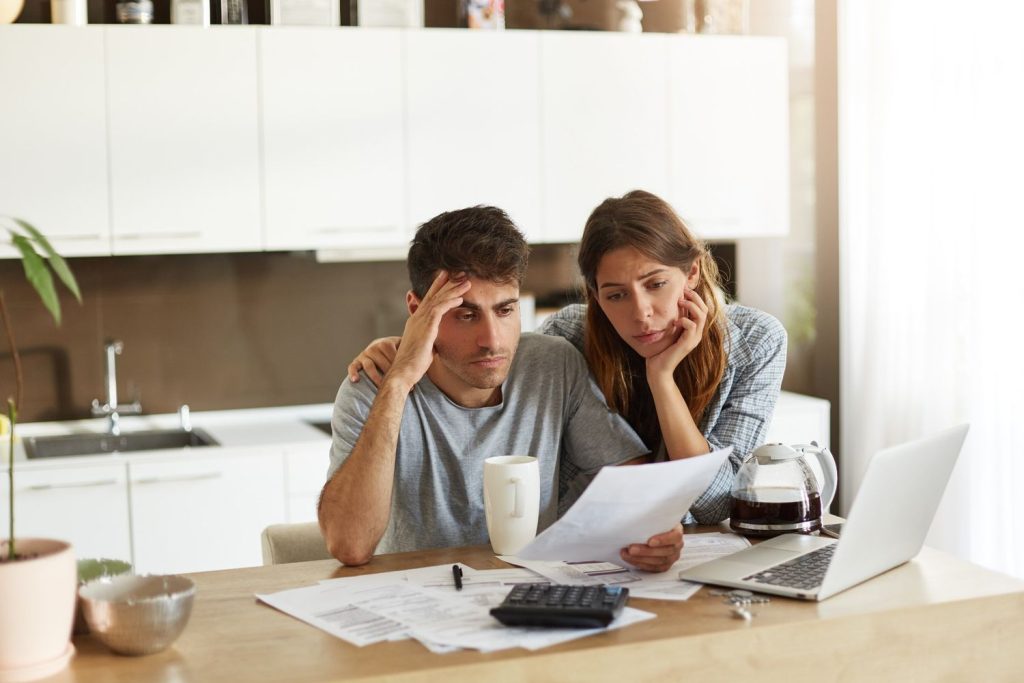 A couple reviews bills together and discusses debt consolidation to simplify household debt payments.