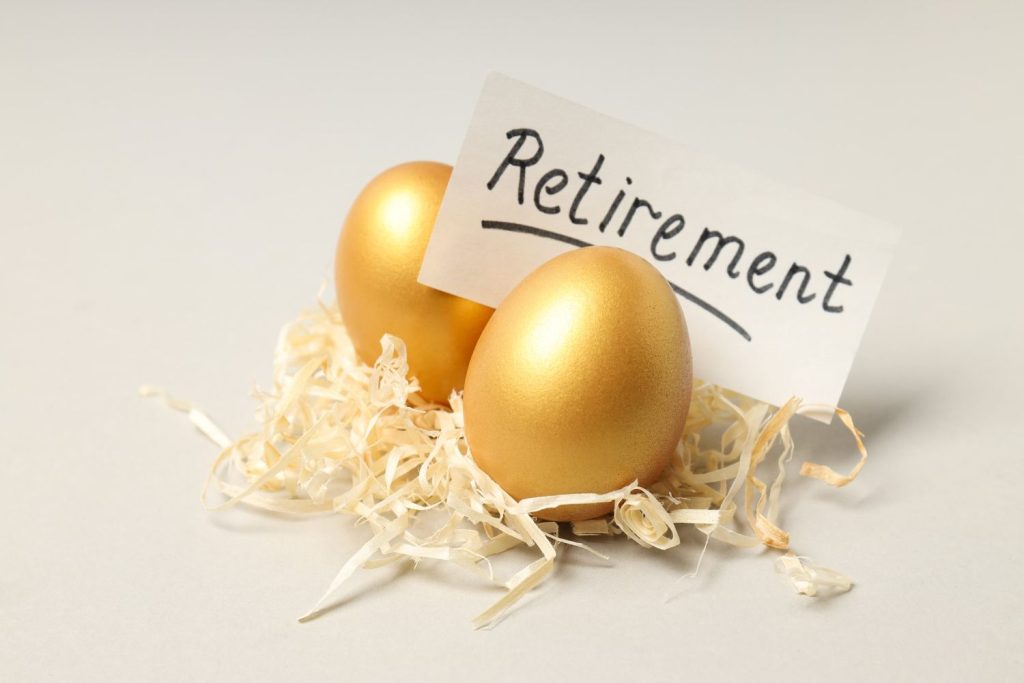 Golden eggs beside a retirement sign symbolize savings and planning to retire comfortably in the future.