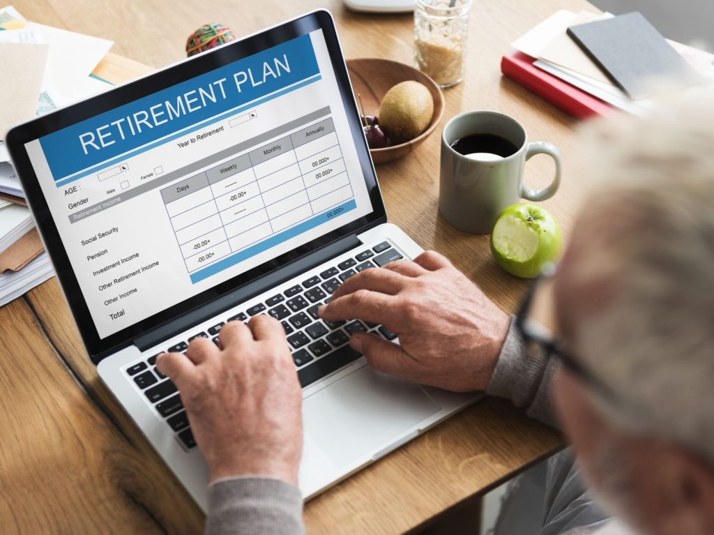 Person reviewing a retirement plan on a laptop while comparing roth IRA vs traditional IRA options.