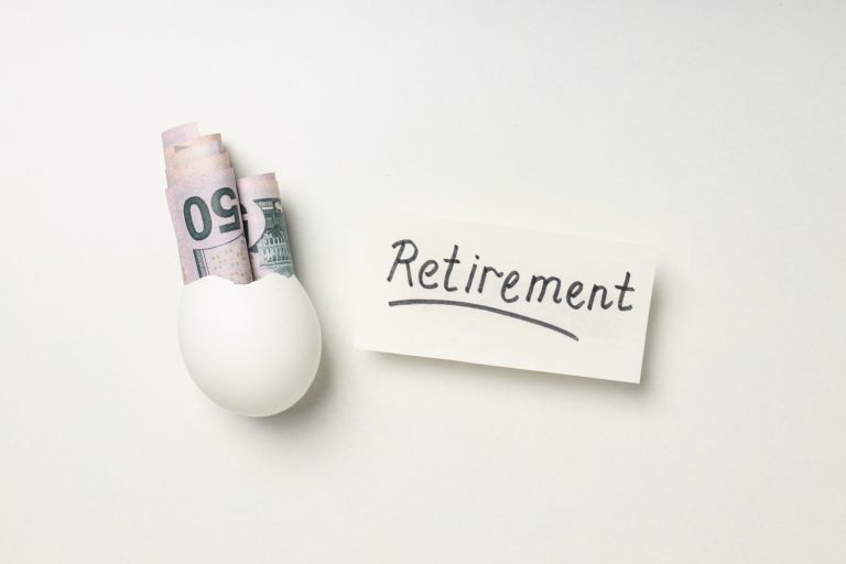 Eggshell holding cash beside a retirement note, illustrating roth IRA vs traditional IRA savings strategies.