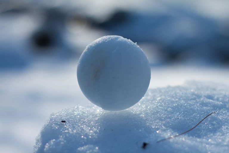 A snowball resting on fresh snow, illustrating the debt snowball method of building momentum by paying off balances.