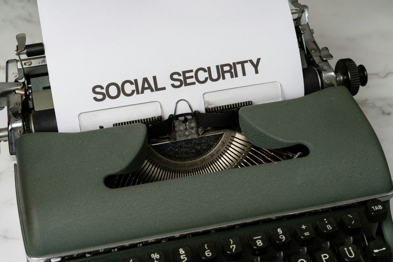 A typewriter prints "Social Security," illustrating Social Security COLA updates and annual benefit adjustments.